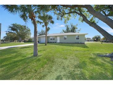 Newly renovated single-story home with a spacious lawn and palm trees at 511 Corto Andra St, Punta Gorda, FL 33950