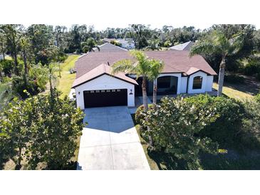 Aerial view of a single-Gathering home with a large yard and driveway at 23155 Adela Ave, Port Charlotte, FL 33952