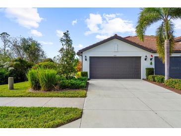 Two-car garage and landscaped front yard of a single-Gathering home at 2481 Daisy Dr, North Port, FL 34289