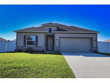 One-story home with gray siding, stone accents, and a two-car garage at 3393 Kacher Rd, North Port, FL 34288