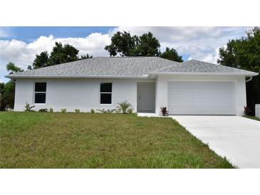 White single-story house with a two-car garage and a well-maintained lawn at 11278 4Th Ave, Punta Gorda, FL 33955