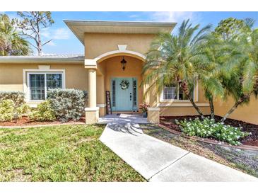 Charming home with a beautifully landscaped front yard and inviting light-blue front door with decorative wreath at 1205 Bartlett Ave, North Port, FL 34288