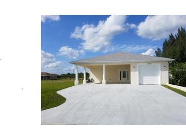 Exterior view of a single-story home with a covered driveway and attached garage at 12090 Malaga Ave, North Port, FL 34287