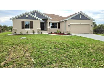 Charming single-story home with tan stucco, gray accents, brown shutters, and a well-manicured lawn at 13480 Allentown Ave, Port Charlotte, FL 33981