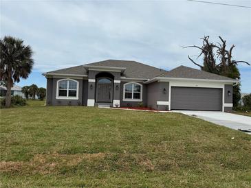 Charming single-Gathering home with gray exterior, arched windows, well-maintained lawn and two-car garage at 233 W Pine Valley Ln, Rotonda West, FL 33947