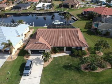 Stunning waterfront home with tile roof, lush landscaping, and boat access to the canal at 3448 Nighthawk Ct, Punta Gorda, FL 33950