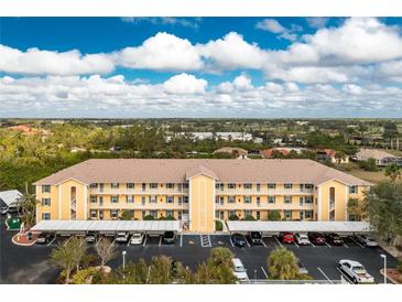 Aerial view of a condo building with parking and lush landscaping at 175 Kings Hwy # 924, Punta Gorda, FL 33983