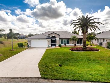 Single-story home with a metal roof, landscaped yard, and palm trees at 17260 Vagabond Cir, Punta Gorda, FL 33955