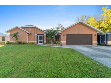 Attractive single-story house with a two-car garage and well-manicured lawn at 1169 Guild St, Port Charlotte, FL 33952