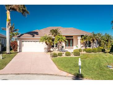 Attractive single-story home with a tiled roof, landscaped yard, and palm trees at 3700 Candia Dr, Punta Gorda, FL 33950