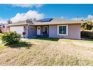 Gray house with a garage and solar panels, nicely landscaped lawn at 5325 Cillette Ave, North Port, FL 34288