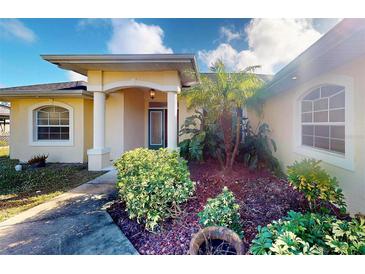 House exterior featuring a covered entryway, landscaping, and a large garage at 158 Eppinger Dr, Port Charlotte, FL 33953