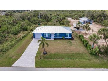 Aerial view of a charming one-story home with a well-manicured lawn and a concrete driveway at 2877 Howe Rd, Port Charlotte, FL 33981