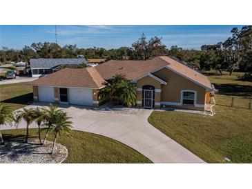 Tan house with palm trees and a large driveway at 3262 Steadman St, Punta Gorda, FL 33980