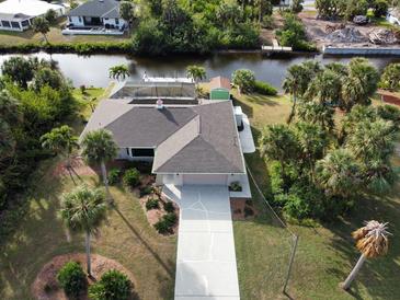 Aerial view of canal-front home with pool, dock, and lush landscaping at 18345 Ohara Dr, Port Charlotte, FL 33948