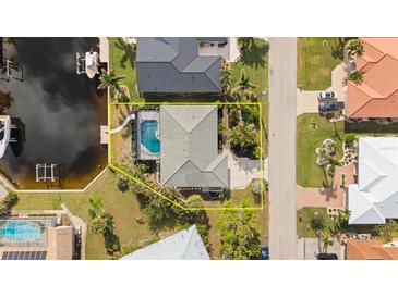 Aerial view highlighting the house with a pool, surrounded by lush landscaping and waterfront access at 210 Divinci Dr, Punta Gorda, FL 33950