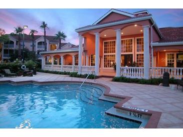 Community pool and clubhouse with classic architecture at dusk at 4178 Central Sarasota Pkwy # 326, Sarasota, FL 34238