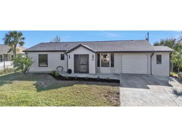 Modern single-story home with a neutral color scheme and landscaped yard at 951 Webster Nw Ave, Port Charlotte, FL 33948