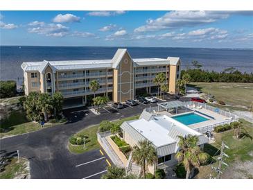 Aerial view of waterfront condo building with pool and parking at 101 N Marion Ct # 225, Punta Gorda, FL 33950