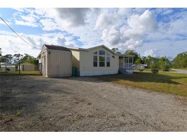 Single-wide manufactured home with shed and gravel driveway at 12415 Catalina Dr, Punta Gorda, FL 33955