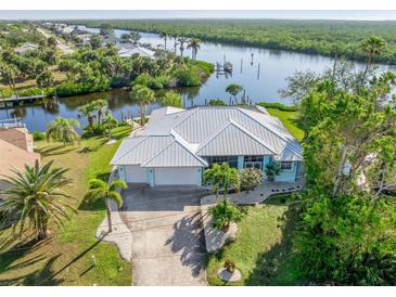 Aerial view of waterfront home with private dock and lush landscaping at 18138 Petoskey Cir, Port Charlotte, FL 33948