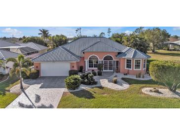 Attractive single-story home with a gray metal roof and a well-manicured lawn at 26081 Templar Ln, Punta Gorda, FL 33983