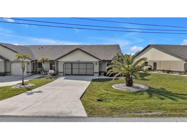 Front view of charming villa with two-car garage and landscaped yard at 26155 Explorer Rd # 1C, Punta Gorda, FL 33983
