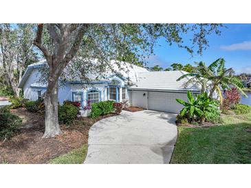 Charming home featuring a well-manicured lawn, lush landscaping, and a convenient two-car garage at 3116 Silkwood Ln, Port Charlotte, FL 33953