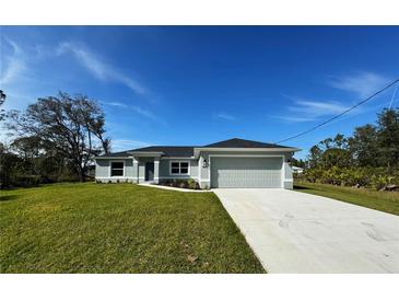 Newly constructed one-story home with attached garage and manicured lawn at 1169 Red Oak Rd, North Port, FL 34288