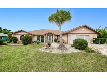 Charming single-story home featuring a mature palm tree and a well-maintained lawn with manicured landscaping at 2259 Kenya Ln, Punta Gorda, FL 33983
