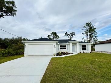 Charming single-story home with well-maintained lawn and attached two-car garage in a quiet neighborhood at 2400 Carpenter Ln, North Port, FL 34286