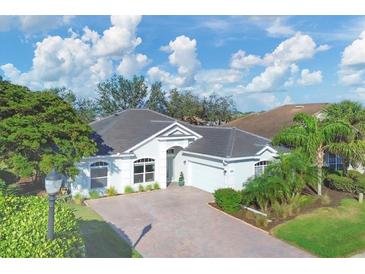 Single-story home with gray roof, white walls, and a paved driveway at 25000 Purple Emperor Way, Punta Gorda, FL 33955