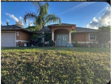 One-story home with attached garage, palm trees, and a manicured lawn at 3323 Sikeston Ave, North Port, FL 34286
