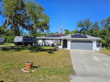 Single-story home with gray garage, solar panels, and RV parking at 430 Hunter St, Punta Gorda, FL 33980