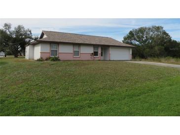 Single-story home with a spacious lawn and attached garage at 1073 Marcus St, Port Charlotte, FL 33952