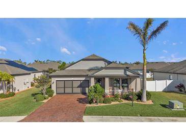 One-story home with brick paver driveway, screened-in garage, and landscaped yard at 15292 Mille Fiore Blvd, Port Charlotte, FL 33953