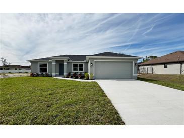 Single-story home with a two-car garage and landscaped lawn at 2965 Vedado St, North Port, FL 34286