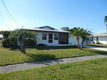 Single-story home with a landscaped lawn and palm trees at 6363 Sooner St, North Port, FL 34287