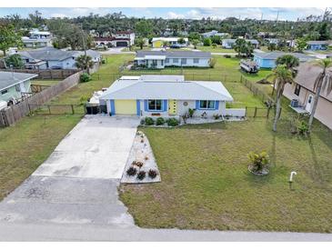 Cute yellow and blue house with nicely landscaped front yard at 817 E 6Th St, Englewood, FL 34223