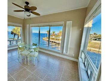 Bright breakfast nook offers stunning waterfront views from large windows, creating a serene dining experience at 1 Colony Point Dr # 3C, Punta Gorda, FL 33950