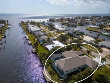 Waterfront home features a private dock, screened-in lanai, and well-maintained landscaping at 193 Beeney Se Rd, Port Charlotte, FL 33952