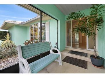 Inviting enclosed porch with a comfortable bench, stylish decor, and a welcoming entrance to the home at 1845 Edison Dr, Englewood, FL 34224