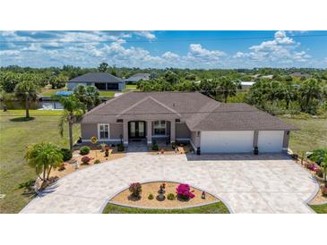 Charming home boasts a three-car garage, well-manicured lawn and tasteful landscaping at 4122 Library St, Port Charlotte, FL 33948