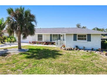 Well-kept single-story home featuring a tidy lawn, established landscaping, and an attached garage at 148 Salem Nw Ave, Port Charlotte, FL 33952