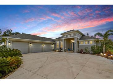 Stunning home with a spacious three-car garage and beautiful landscaping, set against a vibrant sunset sky at 500 Woodstork Ln, Punta Gorda, FL 33982