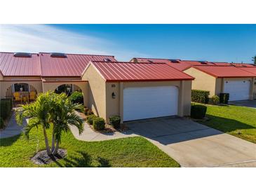 Charming villa with a vibrant red roof, well-manicured lawn, and attached garage at 1780 Deborah Dr # 15, Punta Gorda, FL 33950