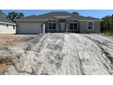 Charming single-story home featuring a two-car garage and craftsman-style details, set on a spacious lot at 17433 Edgewater Dr, Port Charlotte, FL 33948