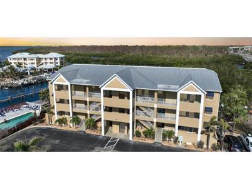Three-story condominium building with a metal roof, multiple balconies, and a convenient parking area at 1960 Oregon Trl # 2B, Englewood, FL 34224