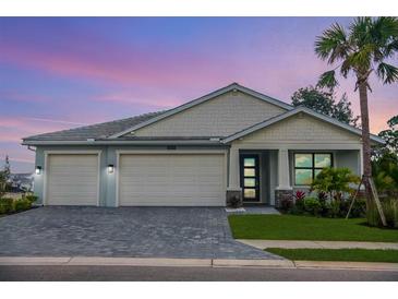 Charming single-Gathering home with a well-manicured lawn, a three-car garage, and beautiful landscaping at 12717 Morning Mist Pl, Venice, FL 34293