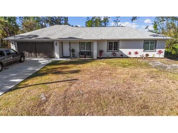 Charming single-story home with an attached two-car garage, beautiful landscaping, and ample curb appeal at 2325 Hanford Ln, North Port, FL 34288